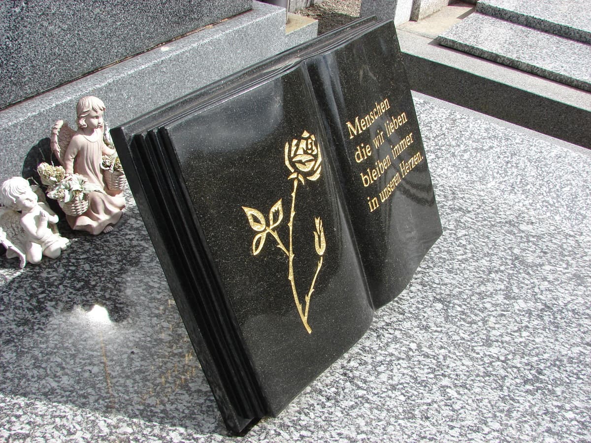 Buchgrabstein aus poliertem Schwarzgranit mit goldener Rose und Inschrift