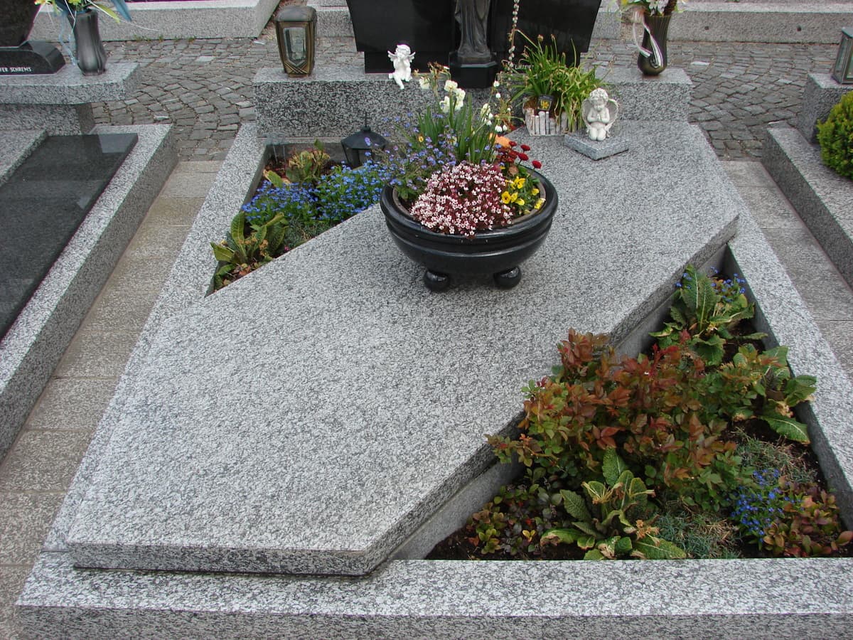 Grabanlage mit asymmetrischer Granitabdeckung und Pflanzbecken